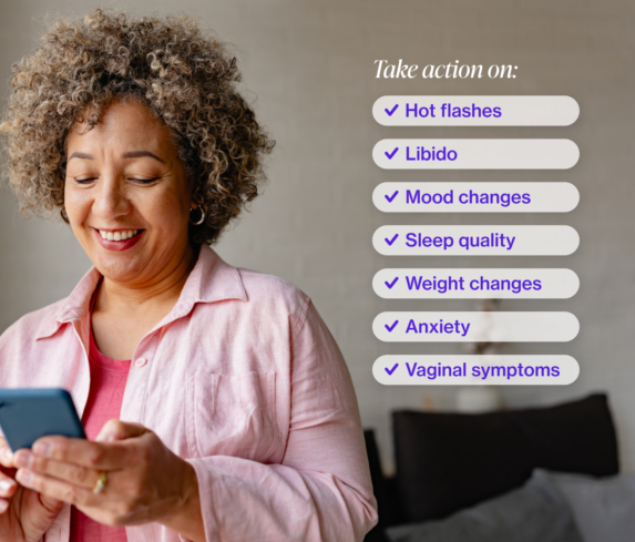 Woman with short curly hair looking at her iphone and smiling