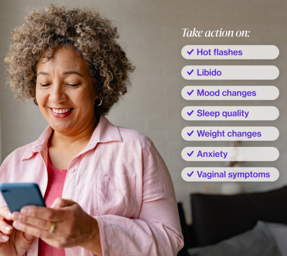 Woman with short curly hair looking at her iphone and smiling