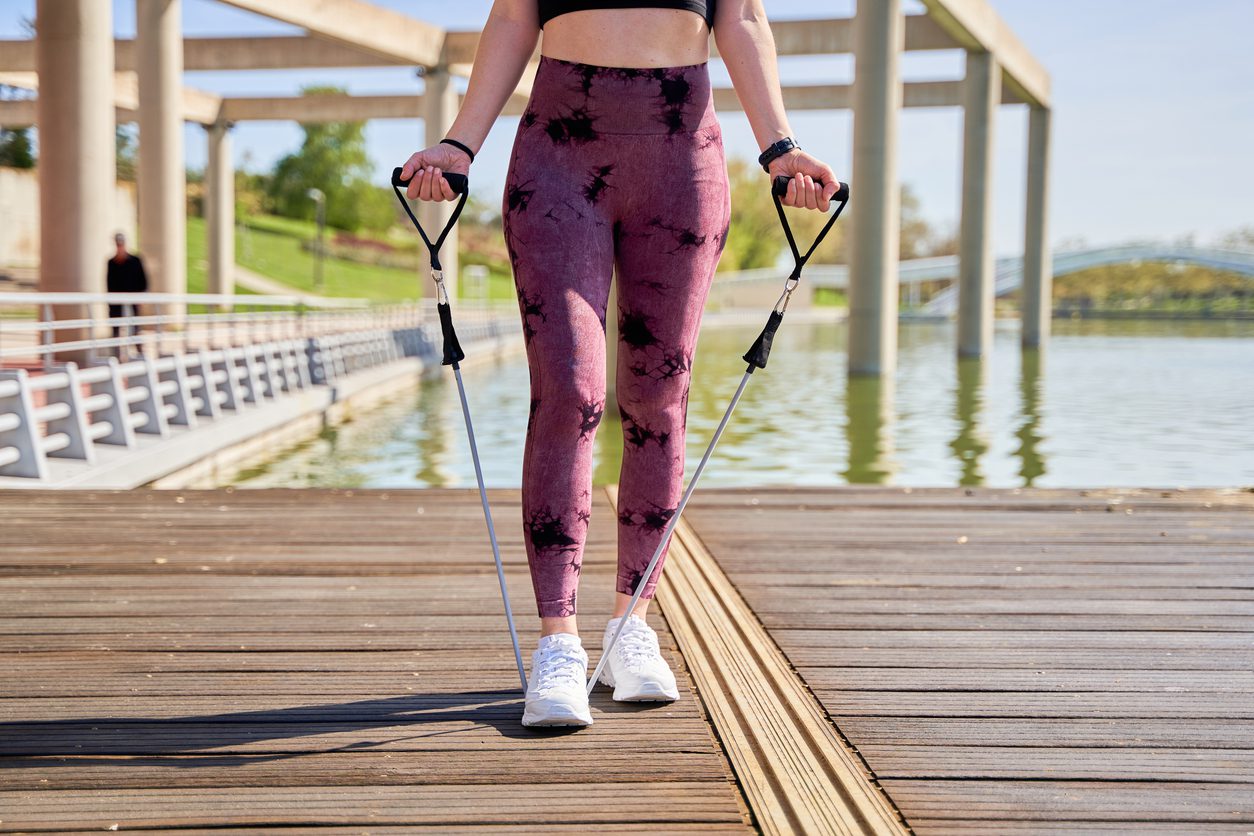 woman doing bicep curl exercise with resistance band