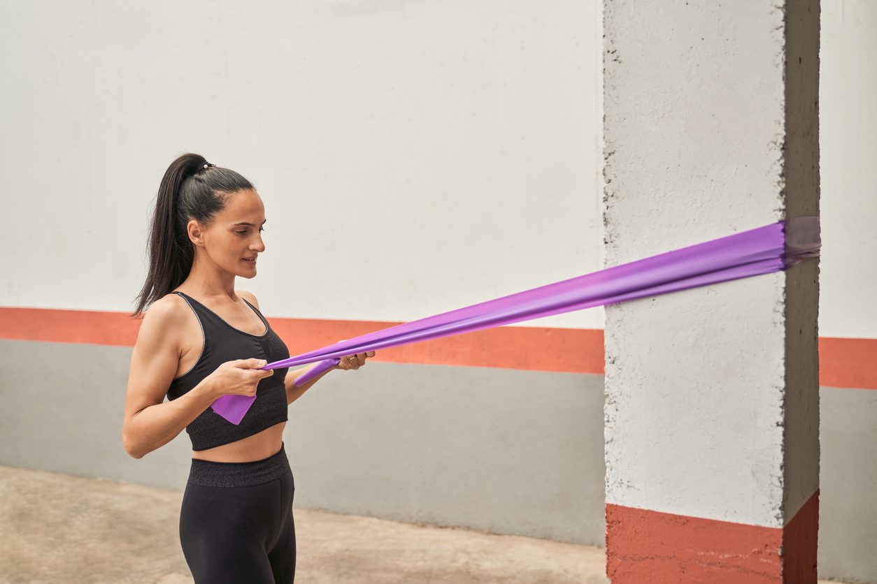 Woman doing face pull exercise with resistance band