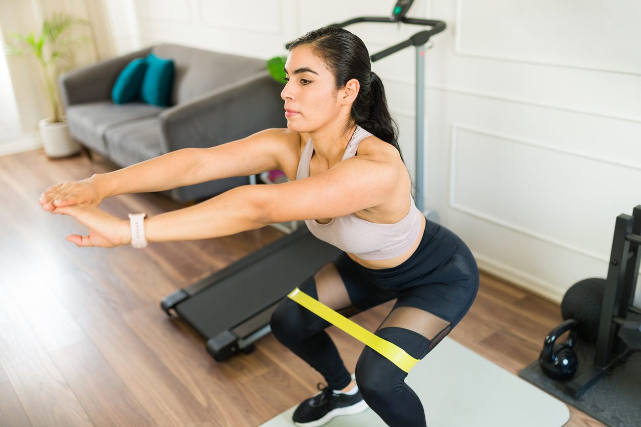 woman doing squat with resistance band