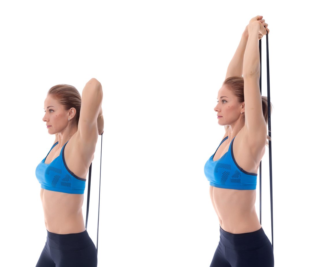 Woman doing tricep extension exercise with resistance band